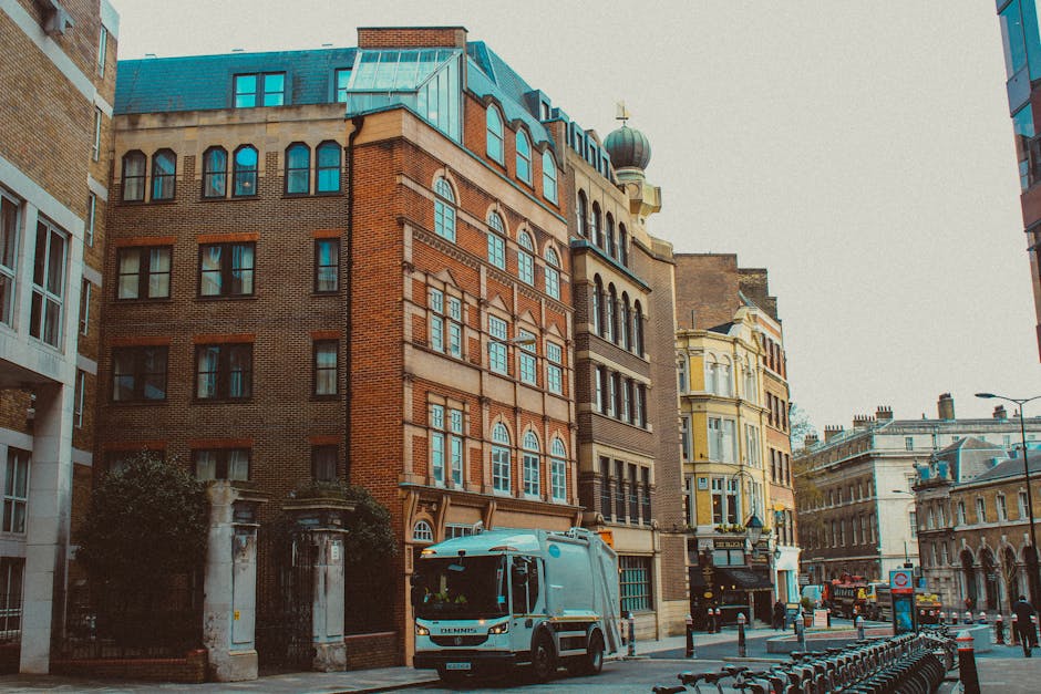 The image depicts a city street scene in Westminster, with a large, multi-storey brick building featuring numerous windows and decorative architectural details. In front of the building, there is a po